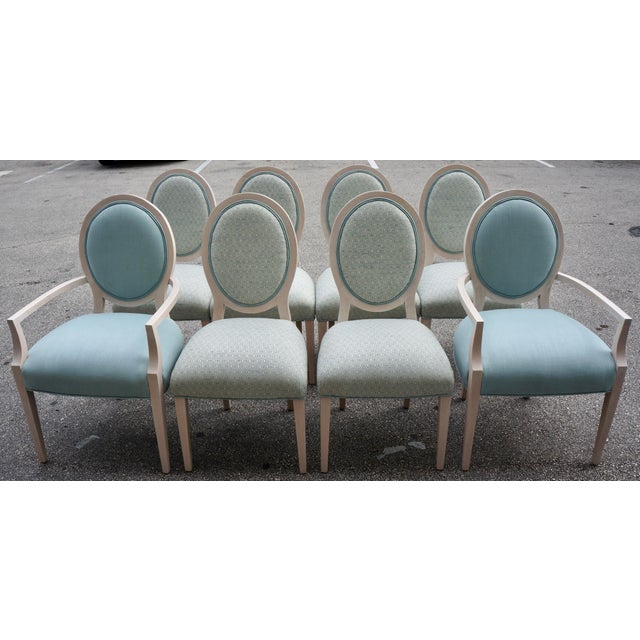 These are Louis XVI style dining chairs featuring light-painted wooden frames and light blue upholstered oval backs and...
