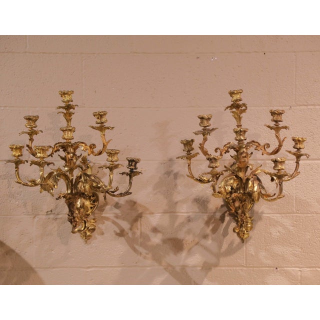 This elegant pair of antique bronze dore sconces was crafted in the Louis XV Rococo style in France during the late 19th...