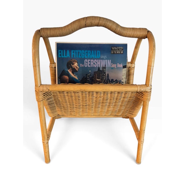 Timeless rattan magazine rack for books, vinyl, or magazines. c. 1970s Dimensions: 15"w x 22"h x 14"d (at feet)
