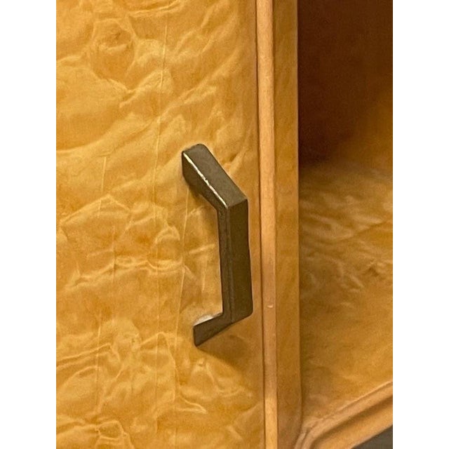 A pair of Italian-made 1960s bedside tables featuring an elegant birch burl veneer and a marbled glass top. The wooden...