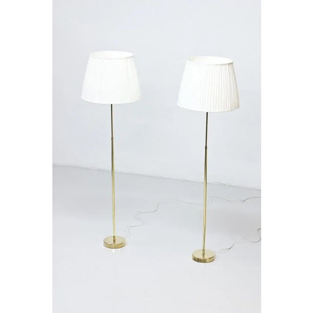 Pair of floor lamps produced by ASEA belysning in Sweden during the 1950s. Polished brass stem. Hand pleated lamp shades...