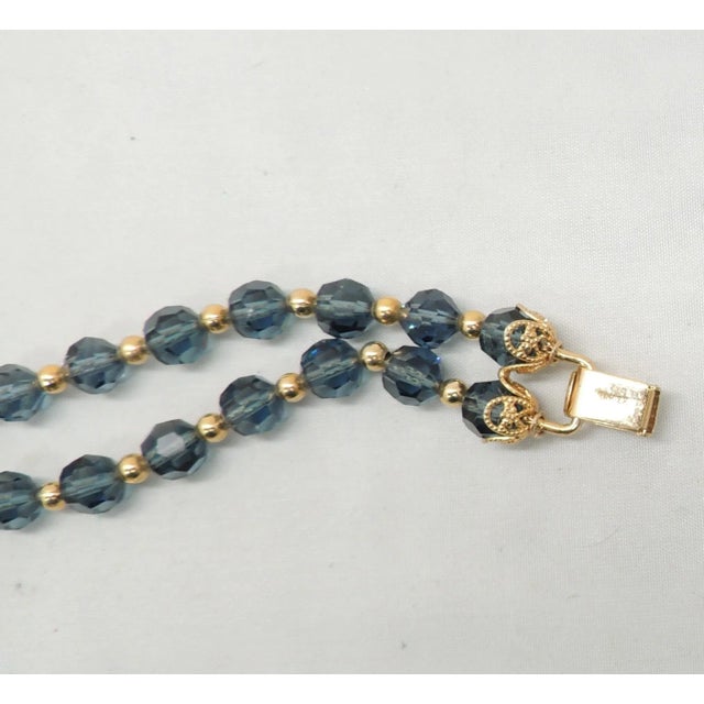 This is part of Chairish’s Costume Jewelry assortment. Goldtone 2-strand faceted blue glass with small goldtone spacer...