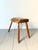 A primitive side table stool with a simple honest construction with splayed legs and an organic slab top retaining its...