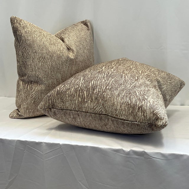 Handcrafted 20”x20” feather/down textured woven pillows in beautiful soft taupe and white against an ivory background....