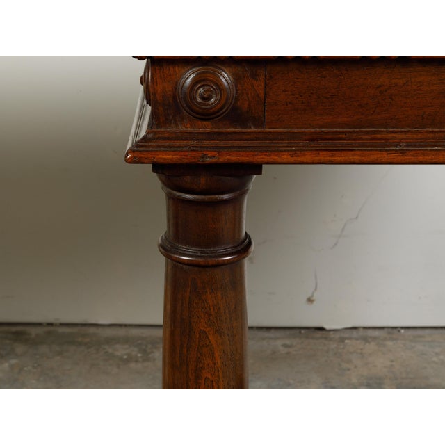 A Pair of Italian walnut console tables from the 19th century, with carved dentil molding and Doric columns. Created in...