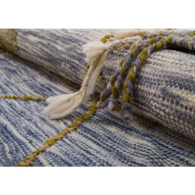 A bold diamond lattice in dark olive green overlays soft horizontal bands of muted blue, purple, and gold in this...