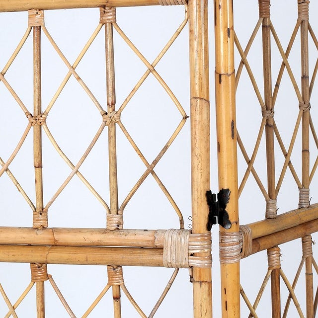 A decorative set of 2 three-panel folding screens made from natural bamboo and rattan, likely dating from the 1970s. Its...
