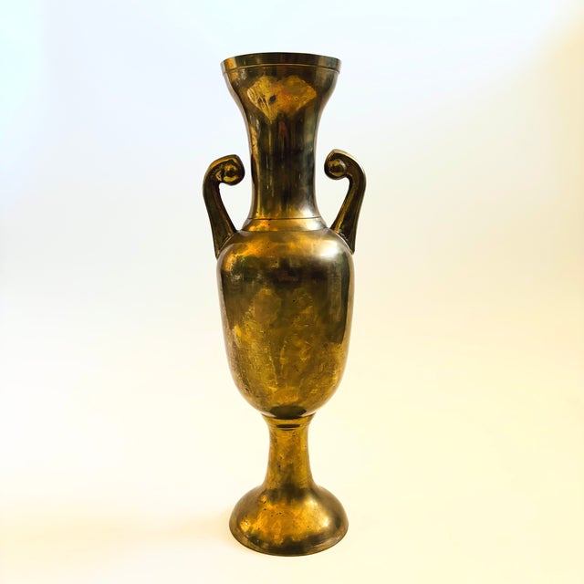 A tall vintage brass amphora vase. Beautiful natural patain with 2 handles formed on the sides. Made in India. Measures...