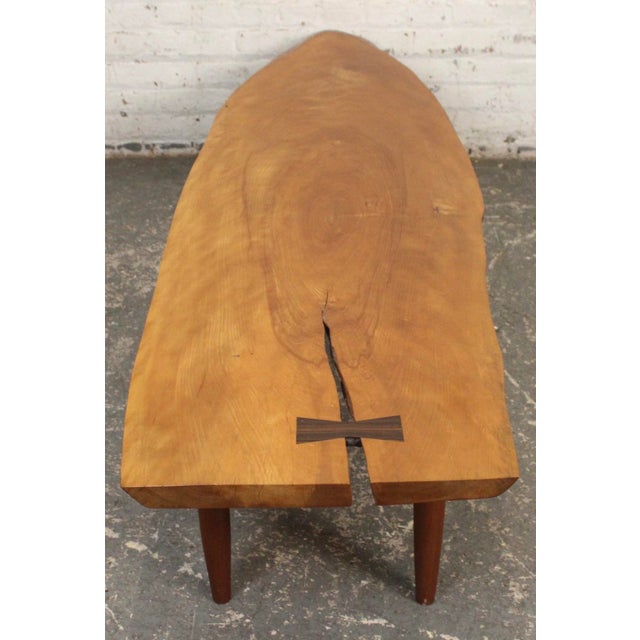 Artist made mid-century style coffee table with a wonderful live edge around the table. Set on tapered legs and featuring...