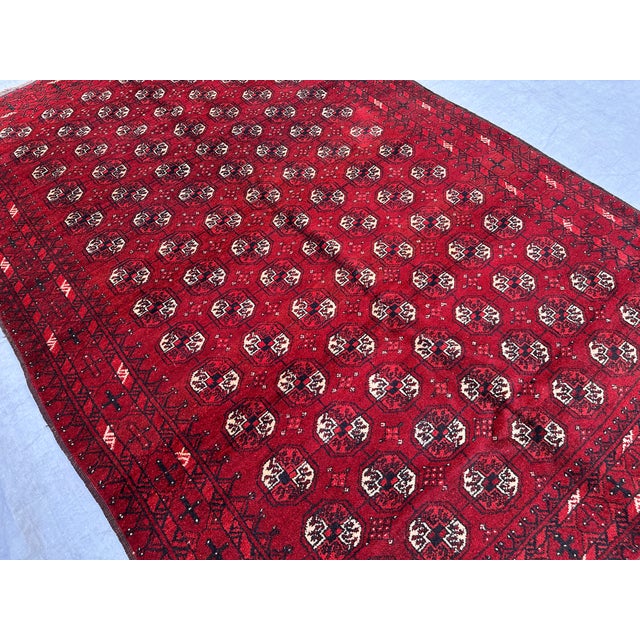 This antique hand-knotted Bokhara rug features dense rows of octagonal "elephant's foot" guls in ivory and black set...
