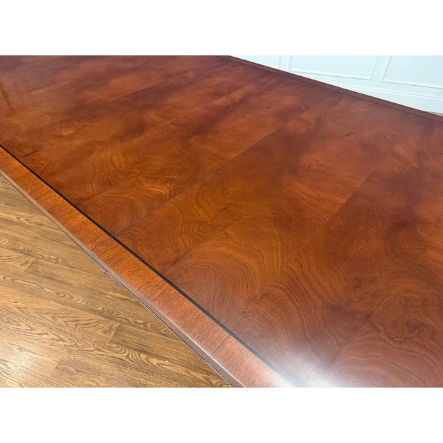 This is a Traditional Oval Banded Mahogany Dining Table by Leighton Hall Furniture. It features a field of swirly crotch...