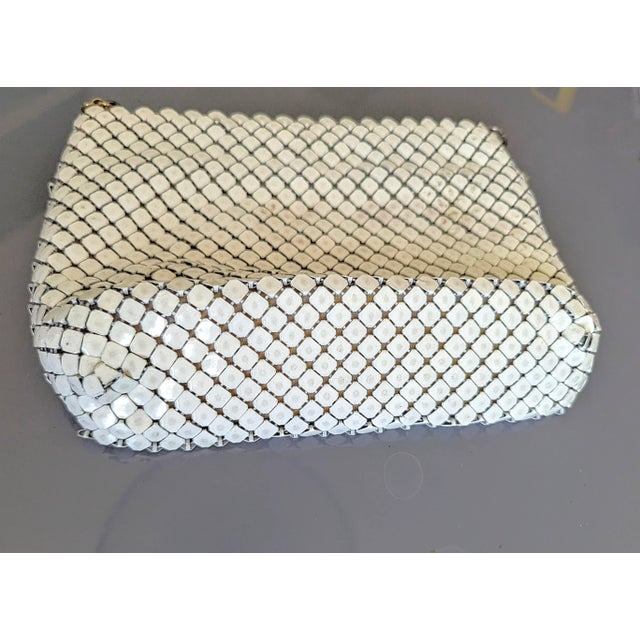 Vintage white enamel over metal mesh makes for unmistakable 70's piece. This purse is very nice and classy and unique...