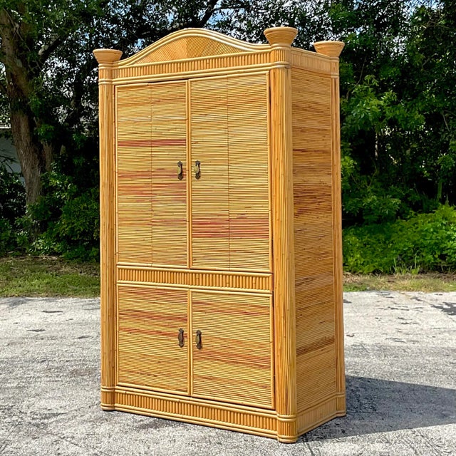 A fantastic vintage Coastal armoire. A stunning pencil reed cabinet with an upper and lower space. Currently outfitted to...