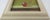 Small painting of an orange egg. Signed on side of frame. John Woods Denver 1997. 7" by 7". ARTIST’S BIO JOHN WOODS...