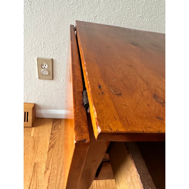 Dating to approximately 1880 and attributed to England, this antique cherry side / work table retains unusually visible...