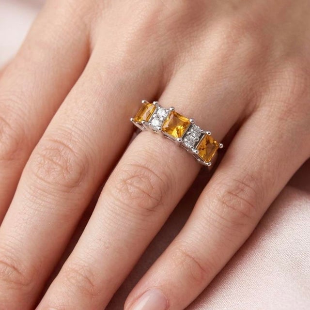 This striking ring showcases a vibrant combination of Citrine gemstones paired with brilliant white accent stones,...