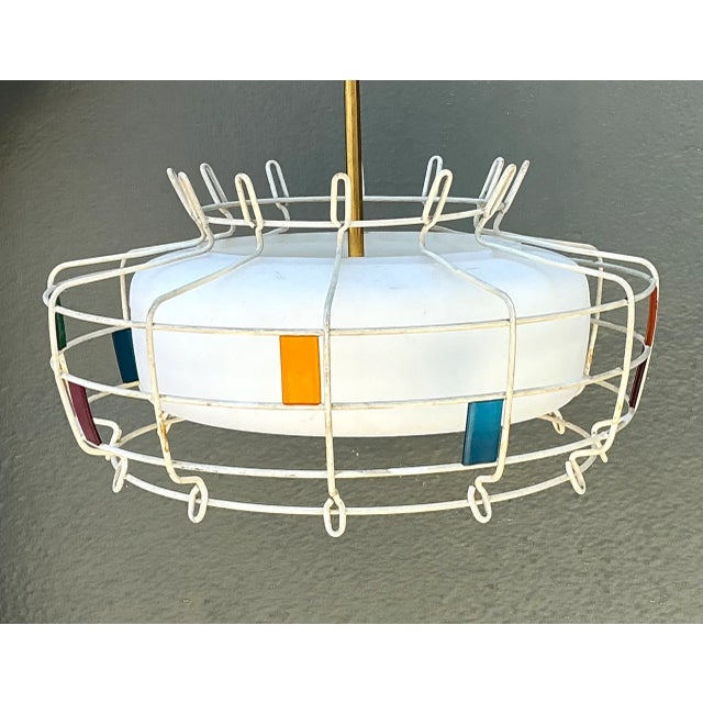 Showcasing playful Space Age design influences, this 1960s vintage pendant light features an architectural wireframe cage...