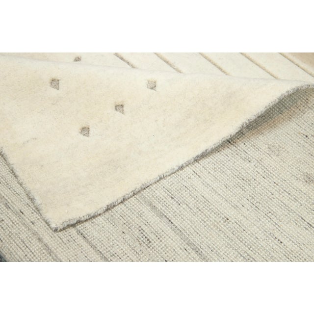 Exquisitely crafted by hand, this modern Moroccan rug features a luxuriously minimalist gray design in the most elegant...