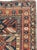 An antique Caucasian Kazak rug from the early 20th century. The warm madder red field is divided into four rectangular...