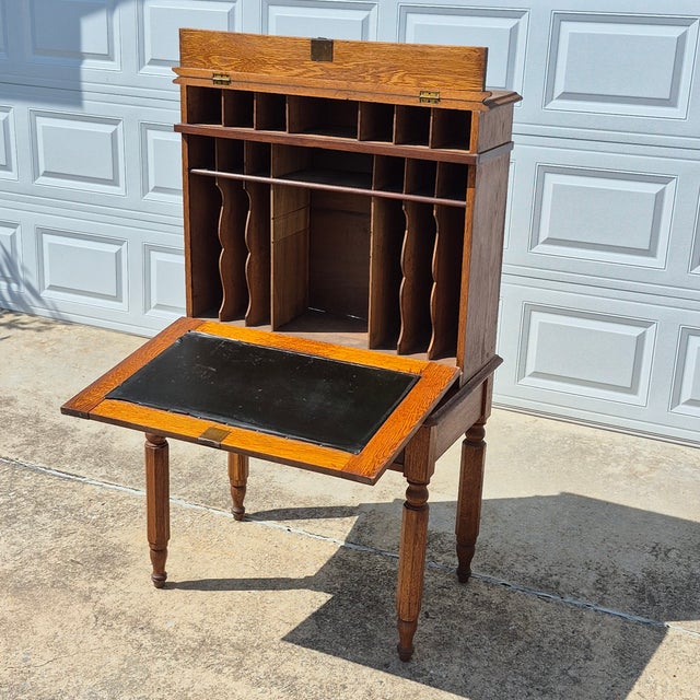 This is an early American plantation style secretary desk, circa 19th century. The solid oak desk is comprised of 2 pieces...