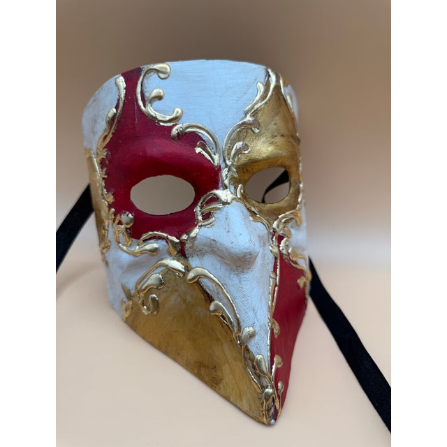 A striking pair of handcrafted Venetian-style masquerade masks, richly decorated in vibrant colors with elaborate raised...