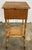 Antique sewing table featuring a rich scorched bamboo finish with woven top and lower shelf surface. Top opens by hinge to...