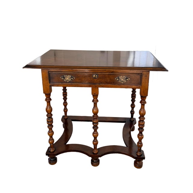 An exquisite example of William and Mary revival craftsmanship, this early 20th century walnut lowboy captures the...