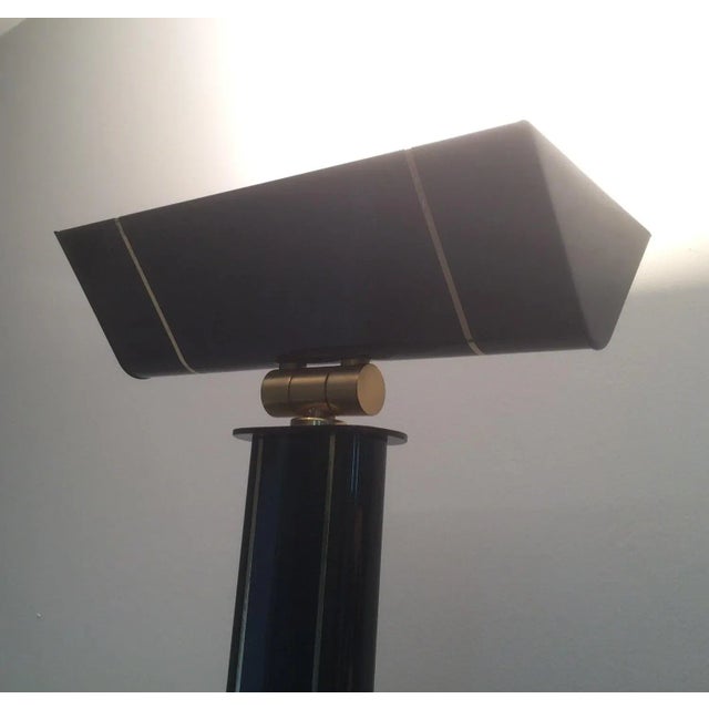 This very elegant floor lamp is made of black lacquered metal and brass. This is an halogen floor lamp. This is French...