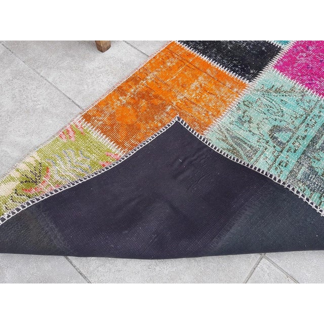 This is a vintage Turkish Oushak rug from the Mid 20th Century. The piece was hand-knotted.