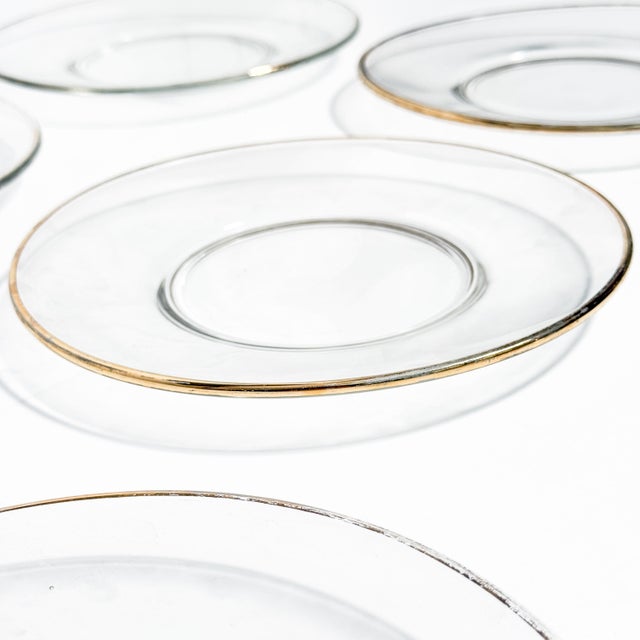Add timeless elegance to your table with this beautiful set of eight vintage clear glass plates featuring classic gold...