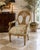 Striking vintage Italian-style Neoclassical armchair featuring an intricately carved giltwood frame with sculptural bird-...