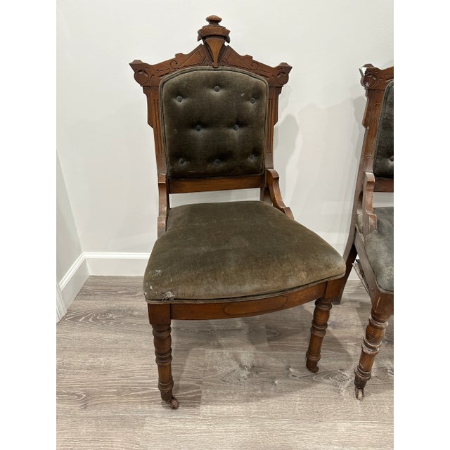 This is a set of two Eastlake style chairs in walnut and velvet. They have castors on the front two legs. Chairs are in...