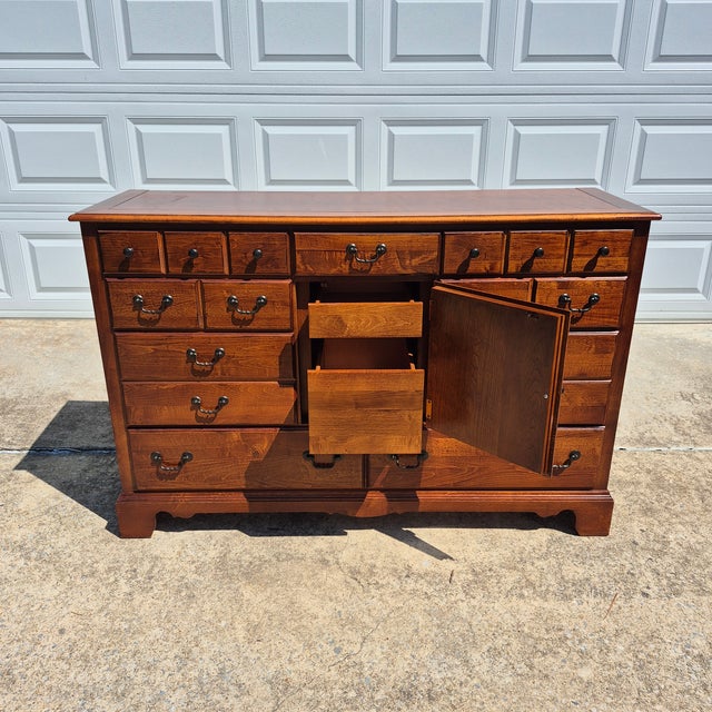 This is a handsome vintage early American or colonial revival style cherry dresser that was made in the United States by...