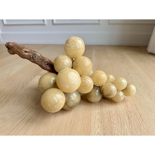 Impressively large mid-century alabaster grape cluster mounted on a twisted natural grapevine stem. The spheres have...