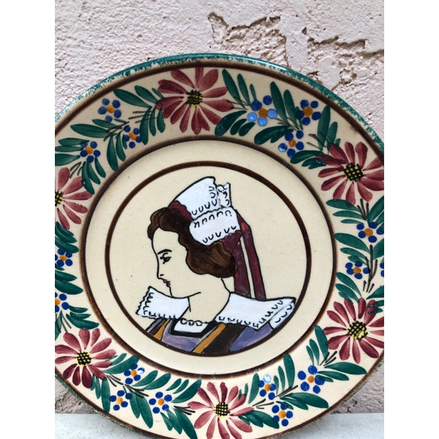 French faience plate Quimper, circa 1920 Border with flowers, representing a woman with a traditional Brittany cap.