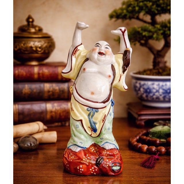 A delightful vintage Chinese ceramic sculpture depicting the Laughing Buddha (Budai), standing with raised arms and a...