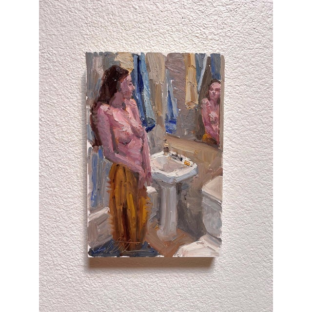 The painting depicts a solitary figure standing before a bathroom mirror, enveloped in soft, muted tones that convey a...