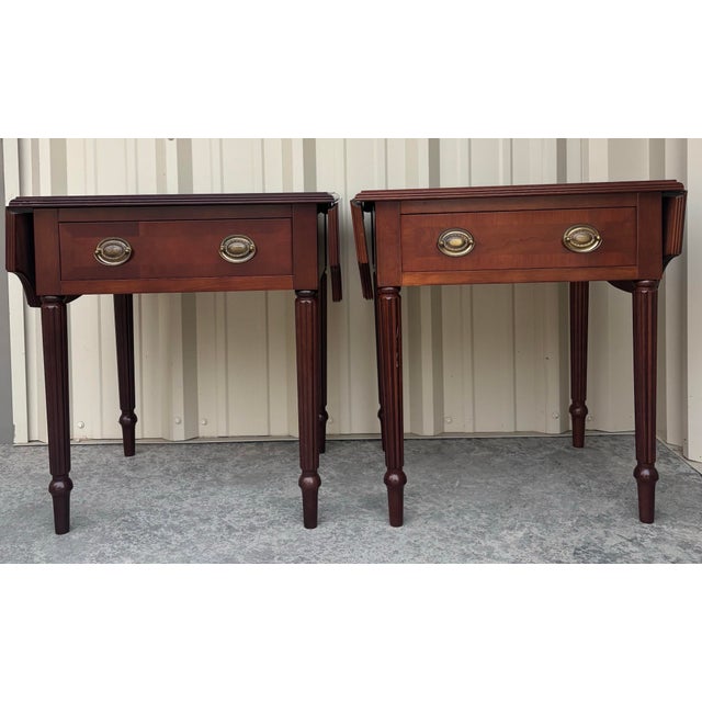 Bring timeless traditional style to your home with this handsome matched pair of Bombay Company mahogany side tables....