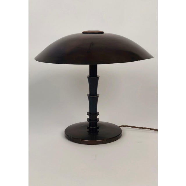 A hand made Art Deco table lamp in a geometric style from brass , 1930's , Vienna. The form of the base has rounded edges...