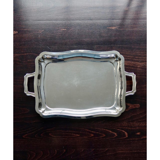 Large silver-plated metal serving tray with a scalloped edge and two molded side handles. Beautiful overall shine, with...