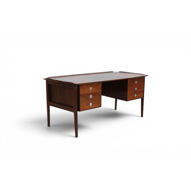 A sleek Danish modern desk in richly grained rosewood, offering clean mid-century lines and a generous work surface that...