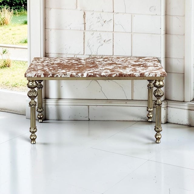 A richly veined French rouge marble top rests on the brass frame of this mid-century neoclassical coffee table. Four...