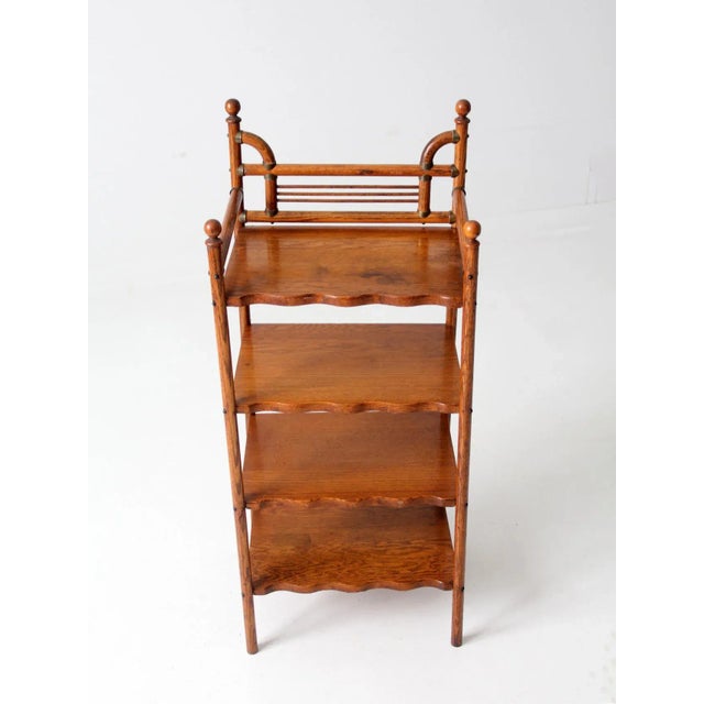 This is an antique etagere. The Victorian era stand features a wood frame with four scalloped wood shelves and brass...