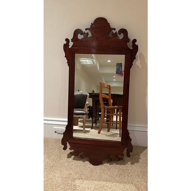 This beautiful mahogany antique mirror is in the Chippendale style and has a rich patina. The color of the wood is warm...