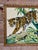 A striking vintage needlepoint textile depicting a leopard moving through lush tropical foliage. The piece features rich...