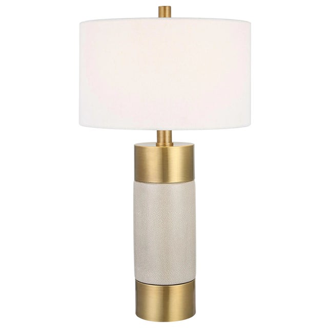 Sophisticated And Versatile, This Table Lamp Displays A Solid Iron Base Finished In Warm Brushed Brass With An Ivory...