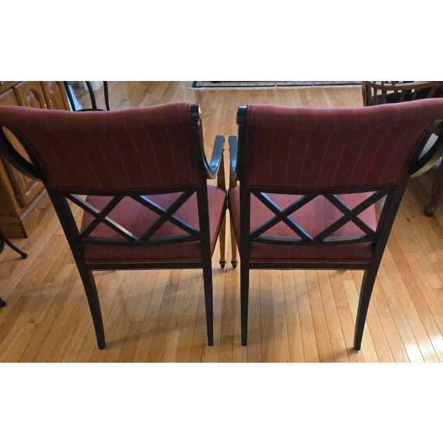 These 1960s Henredon dining chairs designed by Dorothy Draper feature an ebonized black finish with gilded accents....
