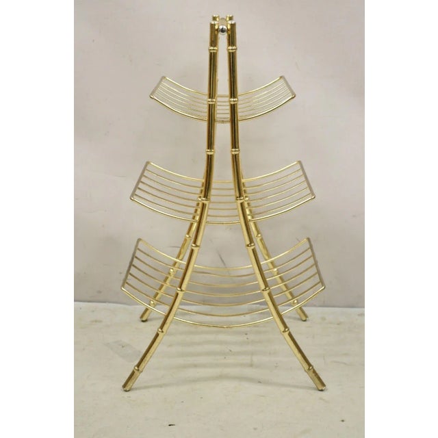 Vintage Gold Metal Faux Bamboo 3 Tier Hollywood Regency Magazine Rack Stand. Circa Late 20th Century. Measurements: 27" H...