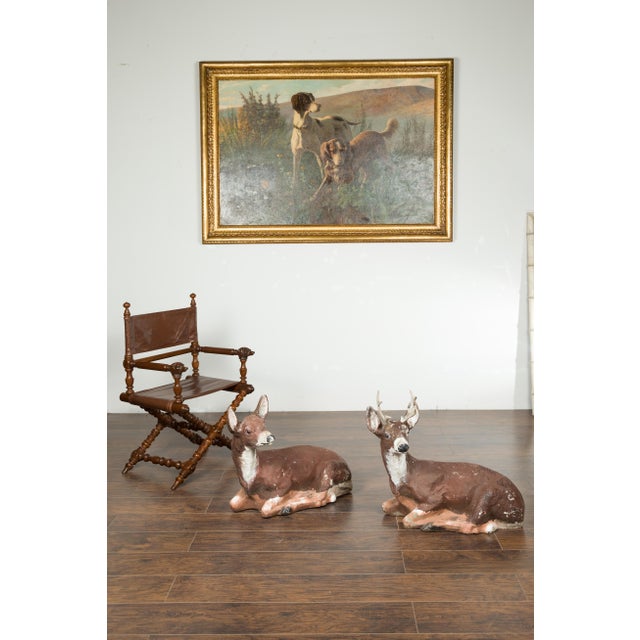 A pair of American painted concrete deer sculptures from the mid 20th century, with weathered patina. Made in the USA...