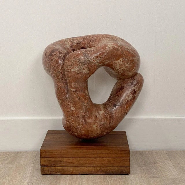 An impressive mid-century figural rouge marble carving, collected in South East Asia, signature inadequate.